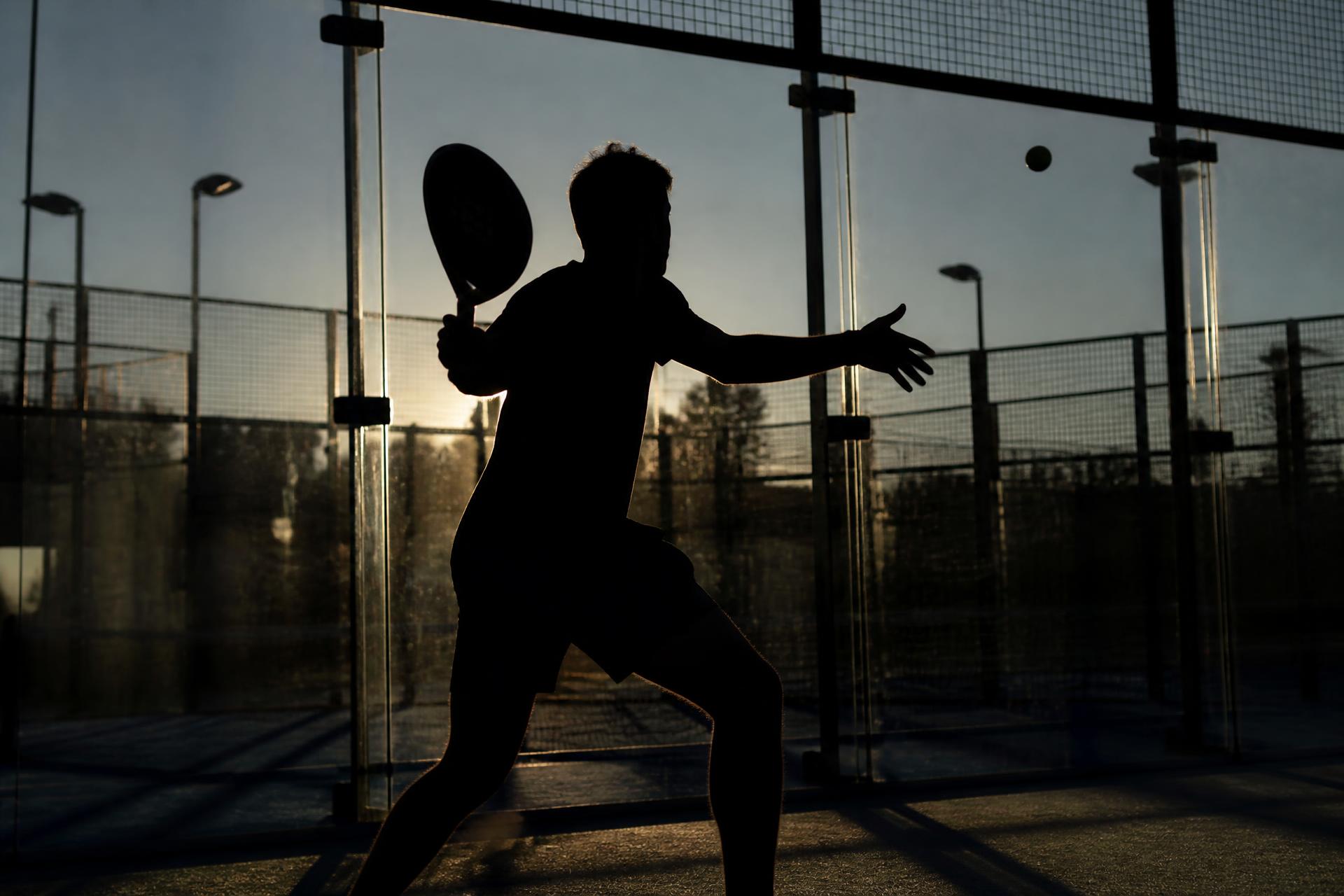 Speler in silhouet tegen glazen wand